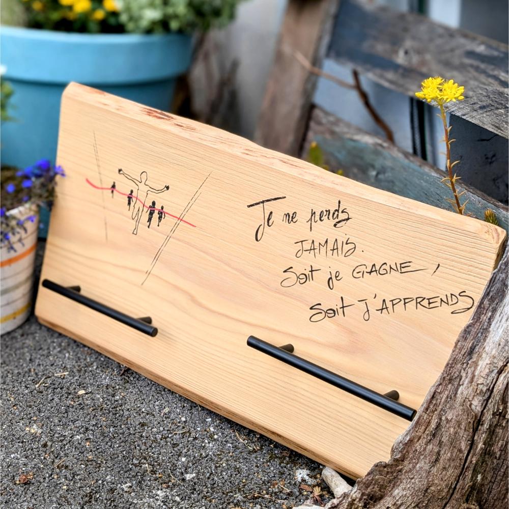 Citation inspiration gravée sur une planche en bois.