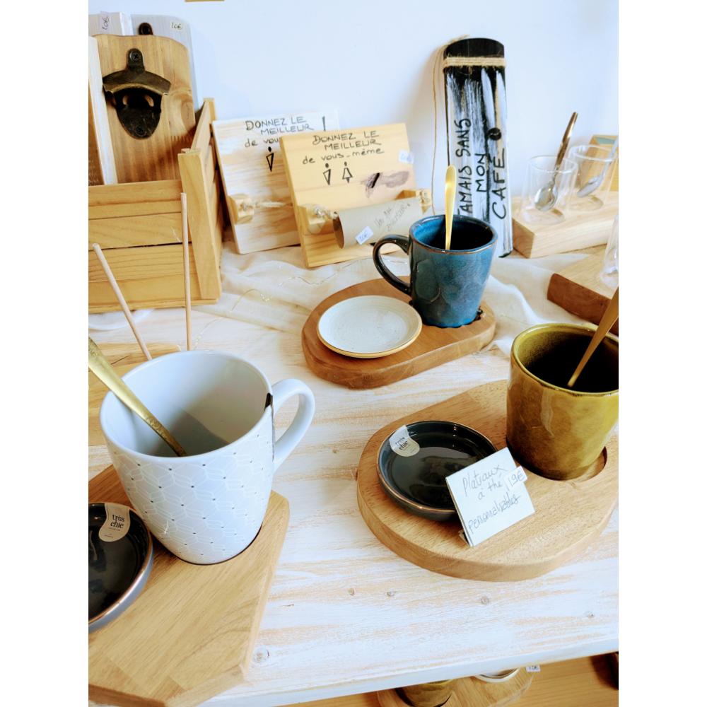 Tasses colorées sur plateaux en bois dans boutique.