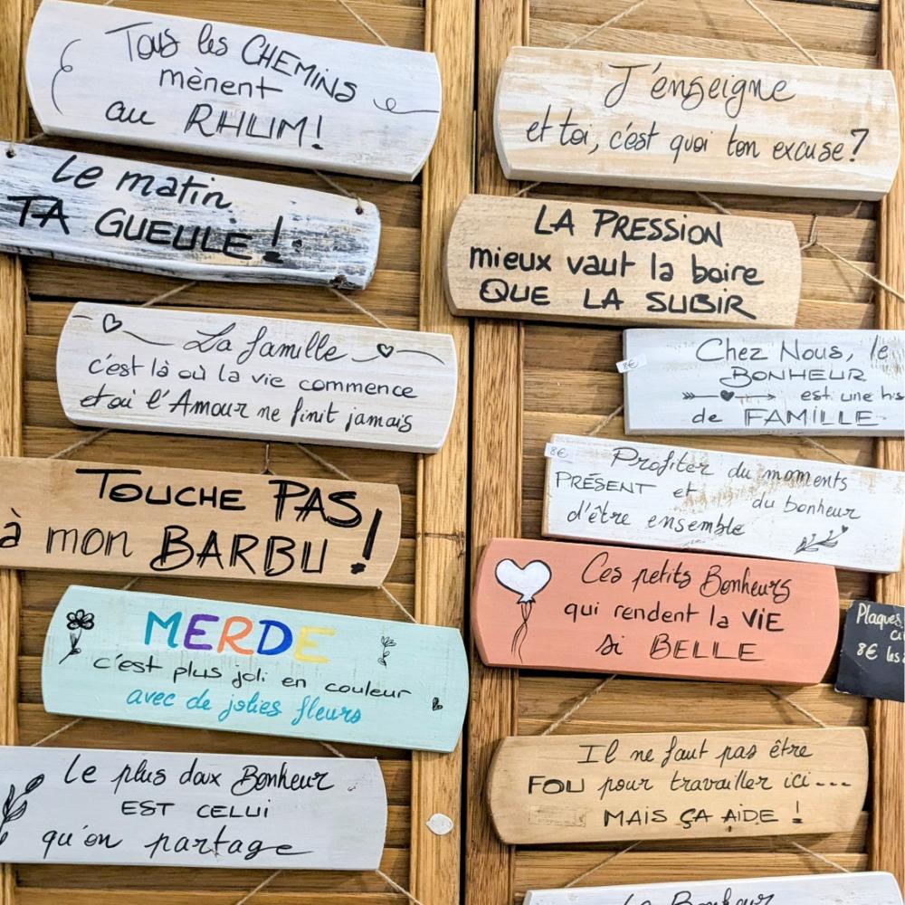 pancarte-plaque-panneau-décoration-maison-cadeau-bois-personnalisé-artisanal-citation Plaques humoristiques et citations inspirantes sur un mur.