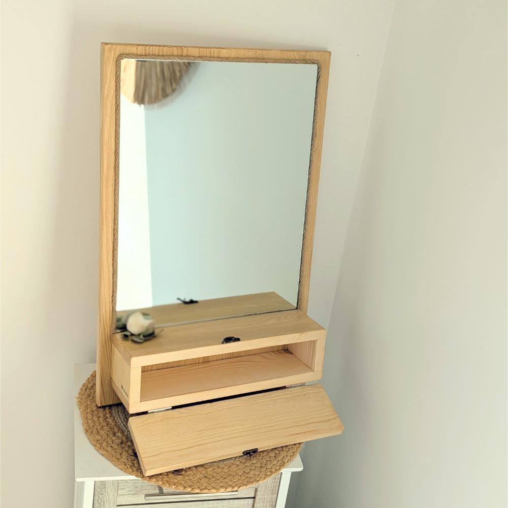 Miroir en bois avec étagère intégrée ouverte.
