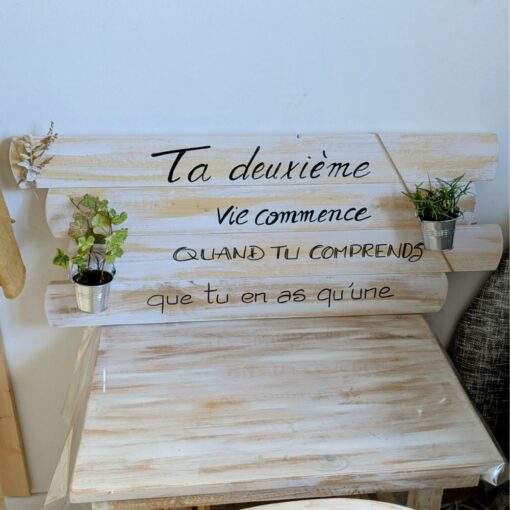 Pancarte en bois avec citation inspirante et plantes.