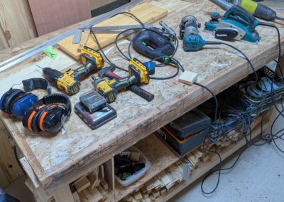 Établi avec outils de menuiserie et bois.