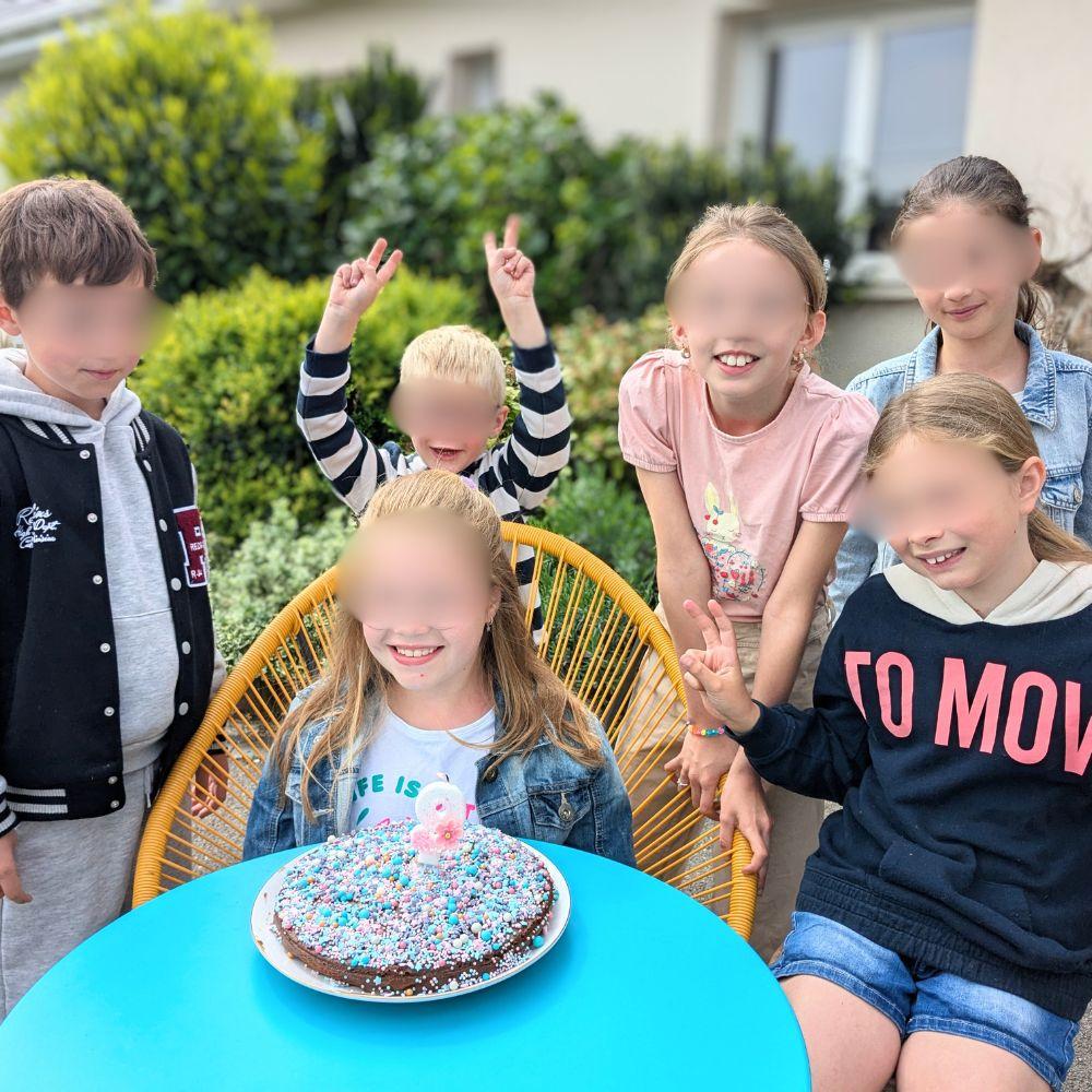 anniversaire-animation-exterieur-creatif-groupe a group of kids sitting at a table with a cake